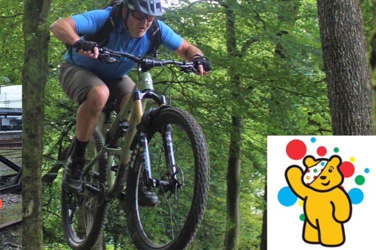 Mark Dix of Forest of Dean in his work gear and on a bike for Children in Need cycle challenge