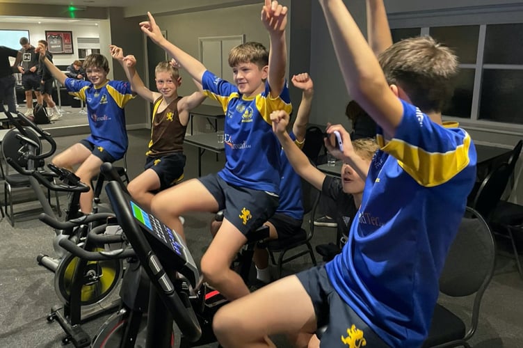 Four members of Monmouth Tigers U-13 team on indoor bikes for cycle challenge