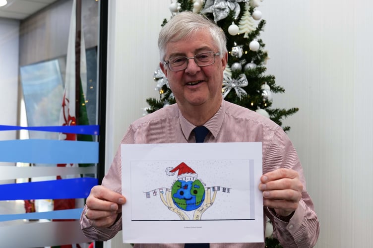 First Minister Mark Drakeford with winning Christmas card design for 2022
