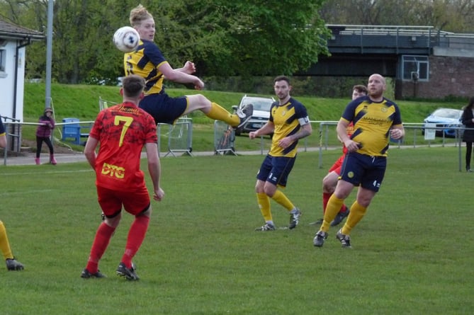 A Monmouth Town player leaps for the ball