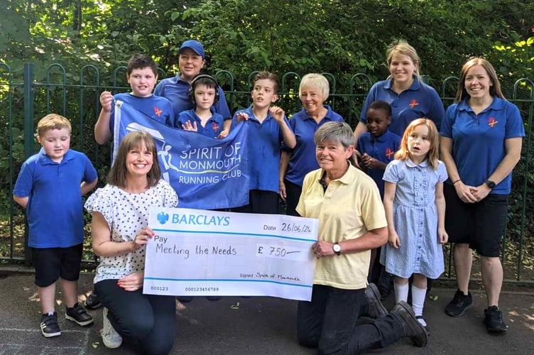 Jayne Whittington, Lead Teacher of Overmonnow Specialist Resource Base (centre left) receiving the cheque from Helen Dunn, Spirit of Monmouth Running Club (centre right), with pupils and staff from the SRB.
