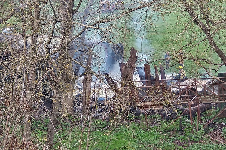 A fireman attends the smouldering scene on vauxhall