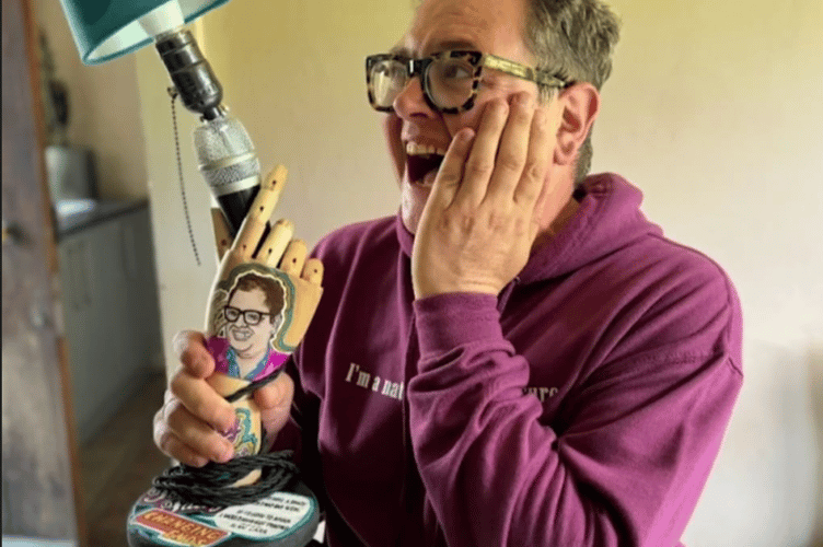 Comedian Alan Carr looking pleased to see his new hand lamp