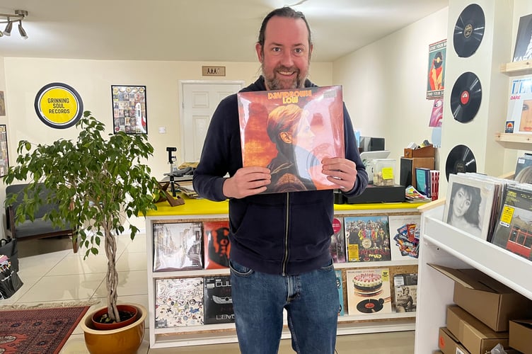 One of the owners holding one of his favourite records by David Bowie.