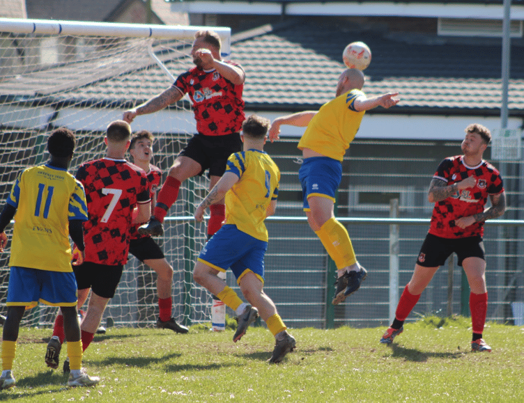 A Monmouth player tries a header in the New Inn box