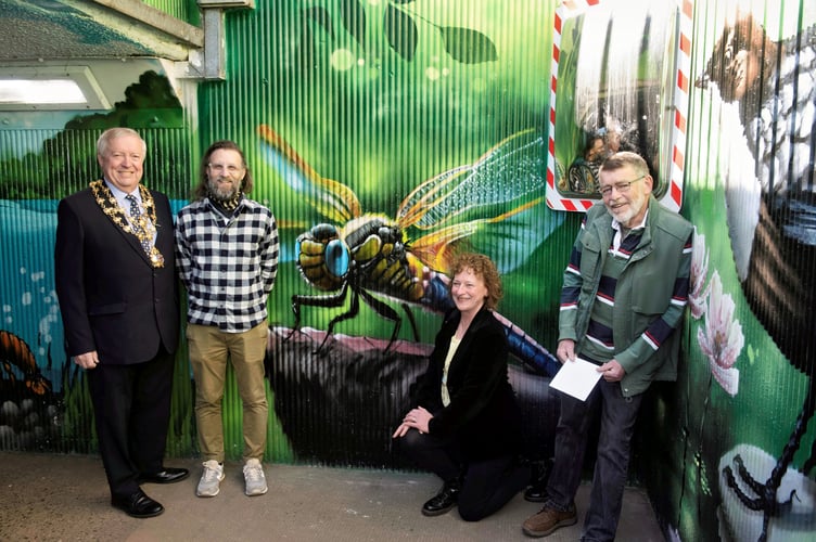 Admiring the dragonfly, part of the underpass mural