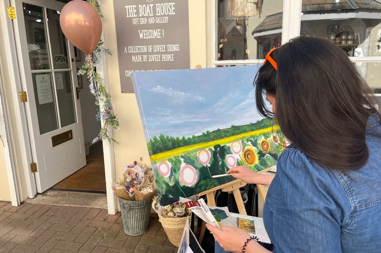 One of the artists painting outside one of the shops- The Boat House gallery and gift shop.