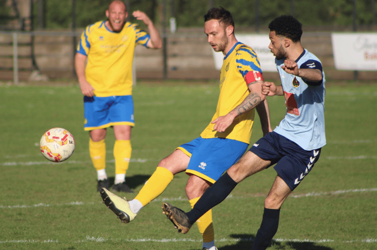 A Monmouth player is first to the ball against Pill