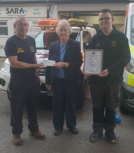 Royal Society of St George branch secretary Margaret Fuller and Tyler Carpenter present a cheque to Mark Powell, SARA's site manager at Beachley.