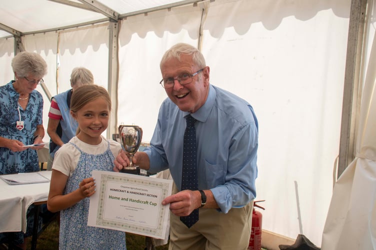 Hatty Anne Eva receives the Home and Handicraft Cup for nine-13-year-olds from show president Alan Evans,