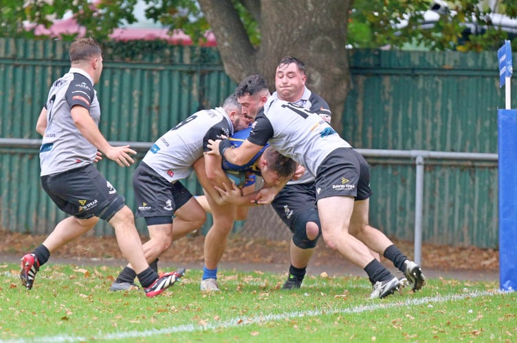 Max Wiltshire is held up by three Nelson defenders