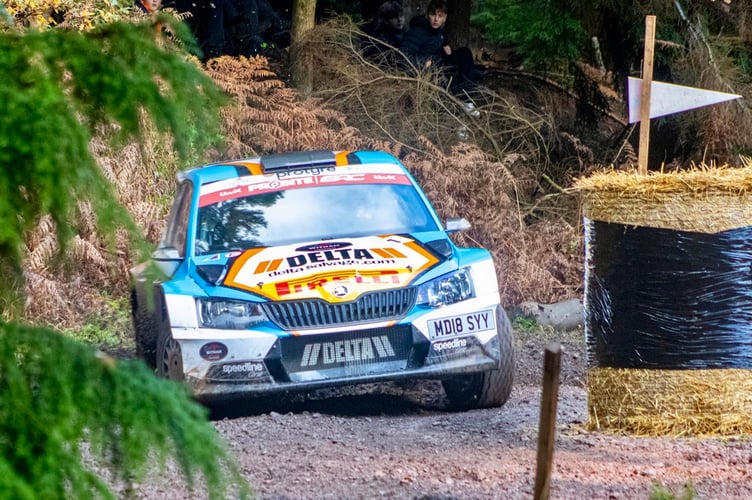 A rally car negotiates a tight turn on one of the Forest stages
