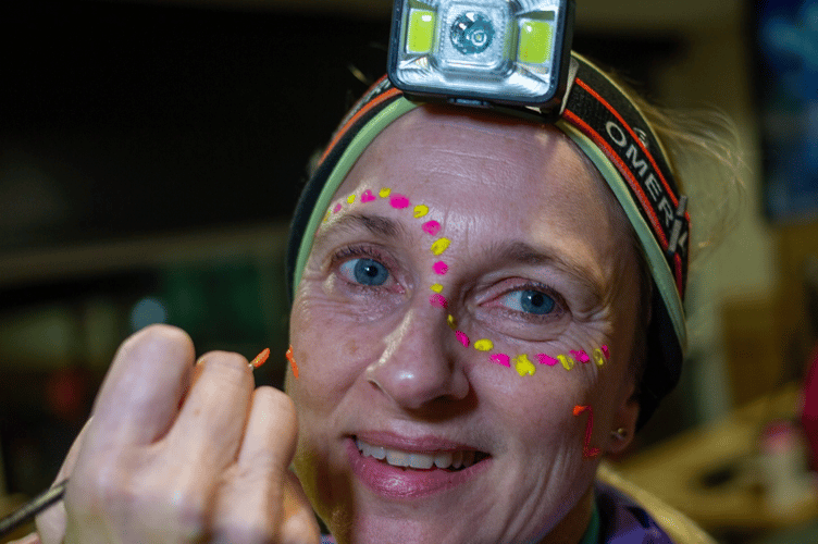 A runner gets ready with face paint and head torch