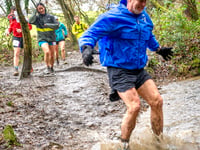 Spirit runners splash through puddles and mud