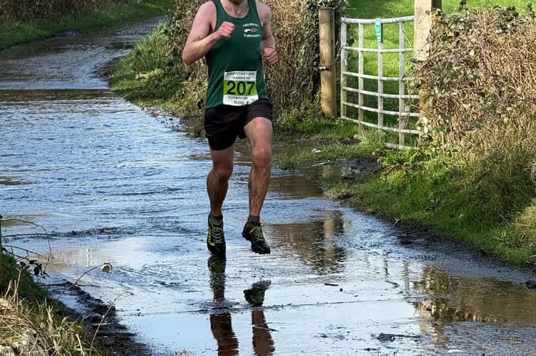 Gavin Jones runs through a watery lane