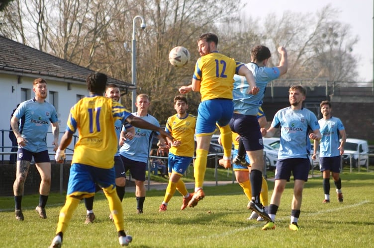 A Monmouth player gets a header in  against Sifil.