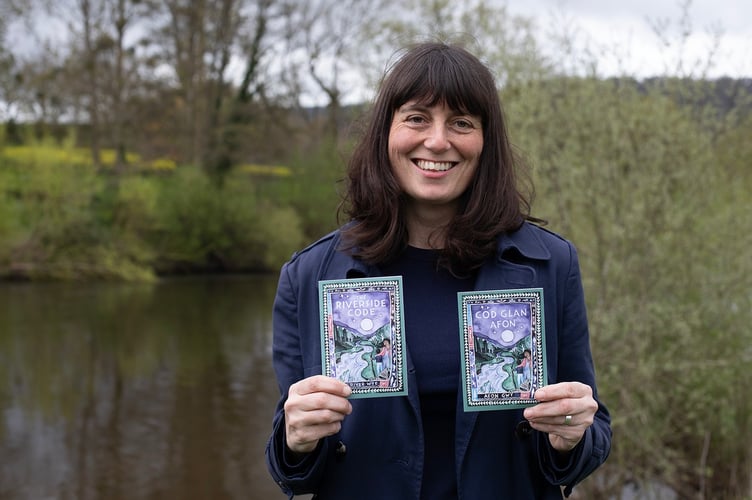 Nicola Cutcher, Co-Chair of Friends of the River Wye, holds copies of The Riverside Code in English and Welsh