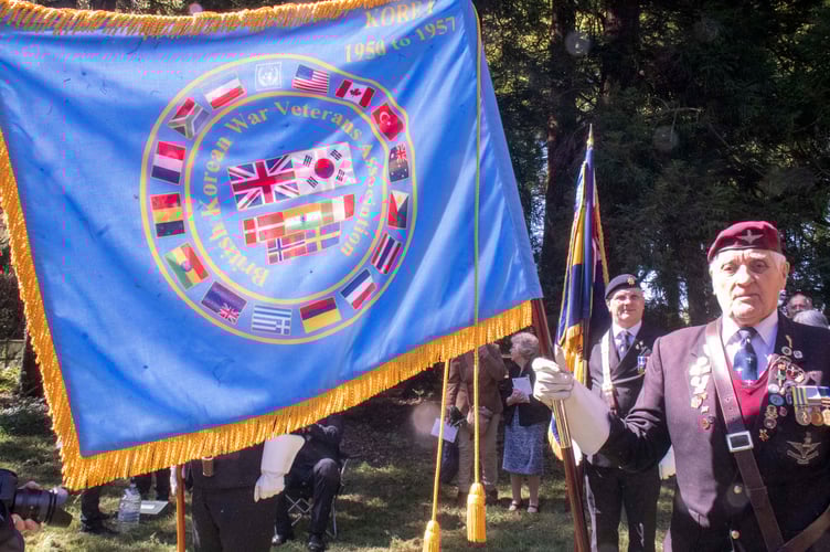 Veteran Peter Galloway with the standard of the Korean Veteransâ Association.